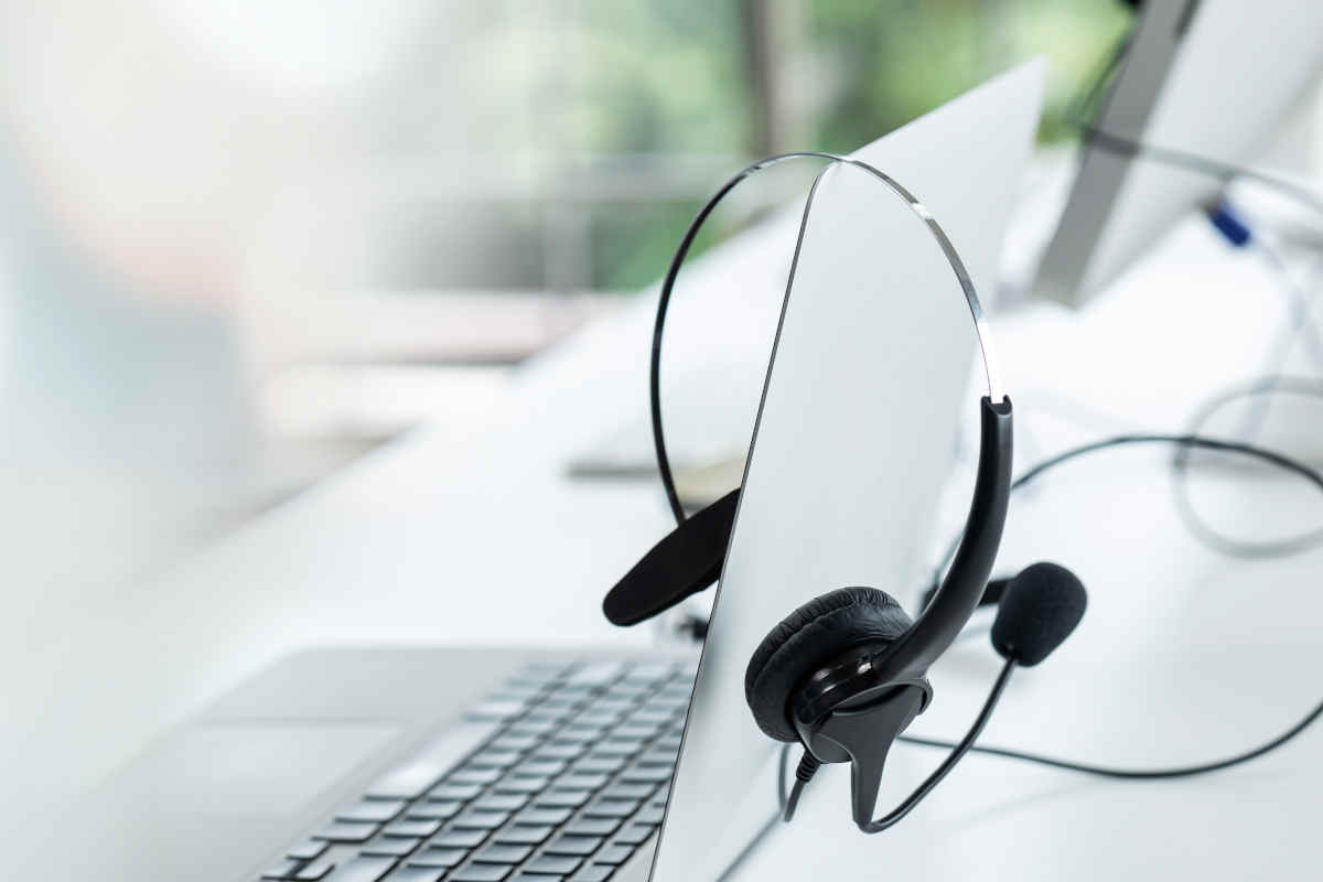 auriculares con micrófono sobre un ordenador portátil para llamadas a clientes