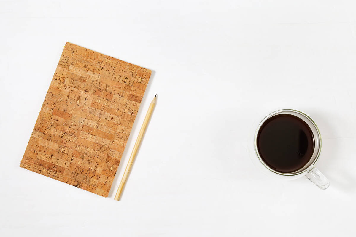 cuaderno lapicero y taza de café caliente