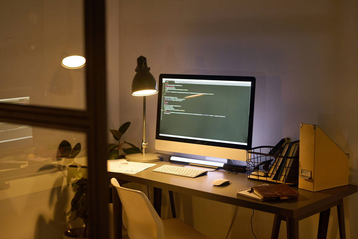 Mesa de ordenador iluminada con lámpara de escritorio